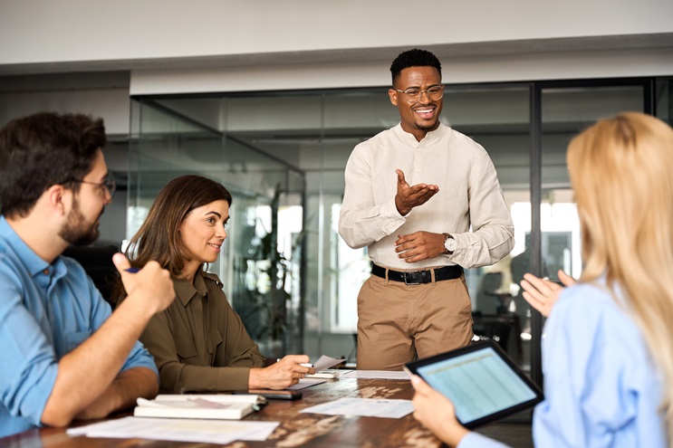 Employees talking together around a table in conference room