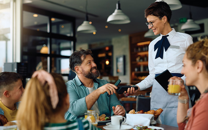 man smiling while paying his bill at a restaurant