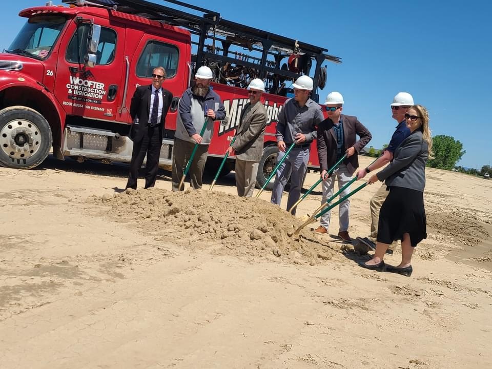 group of six people digging with shovels to break ground on project