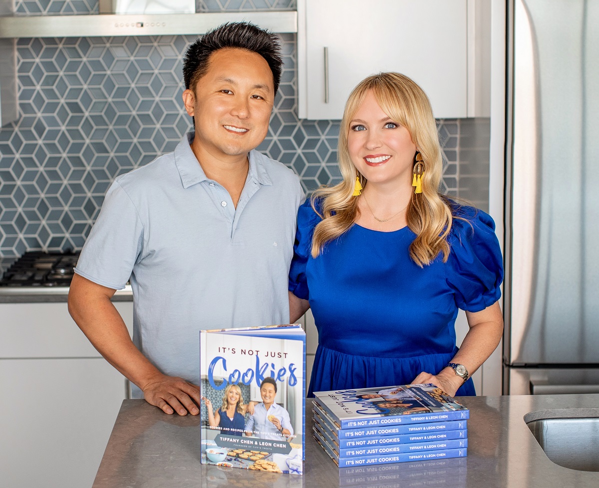 two individuals in a kitchen with a cookbook